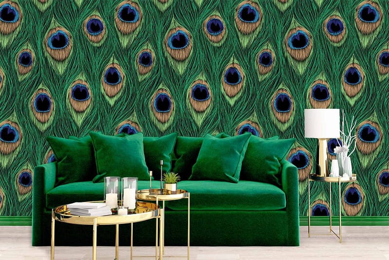 The wallpaper features bold, green peacock feathers with intricate details. There's a prominent mix of lush greens highlighted by accents of iridescent blues and hints of gold flecks throughout the feather patterns. This elegant design brings a luxurious and exotic feel to the space.