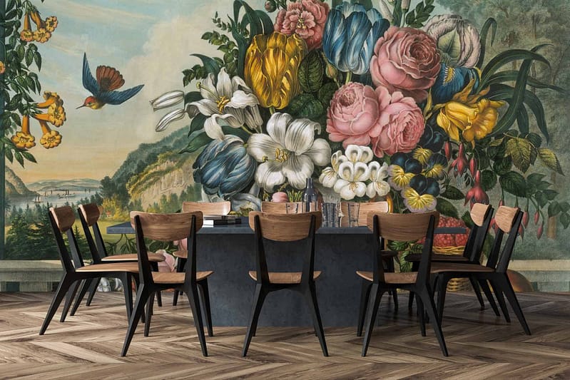 A vibrant mural featuring colorful flowers, green foliage, and a flying bird creates a lush, garden-like atmosphere. Elements include daisies, roses, tulips in shades of red, pink, yellow, and blue. Foliage in varying greens offers depth. The bird adds movement with hues of blue and orange against the botanical background.