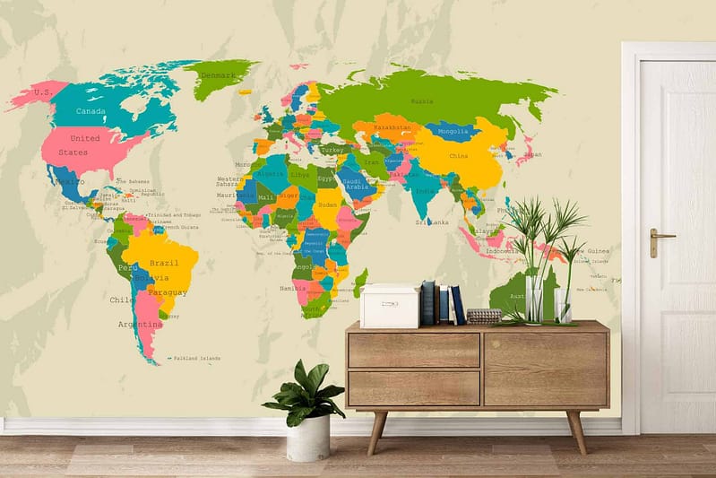A vibrant world map decal on a beige wall featuring countries in bright colors reminiscent of Colour Run hues. Major city names labeled across the colorful continents. The decal includes an adjacent white door.
