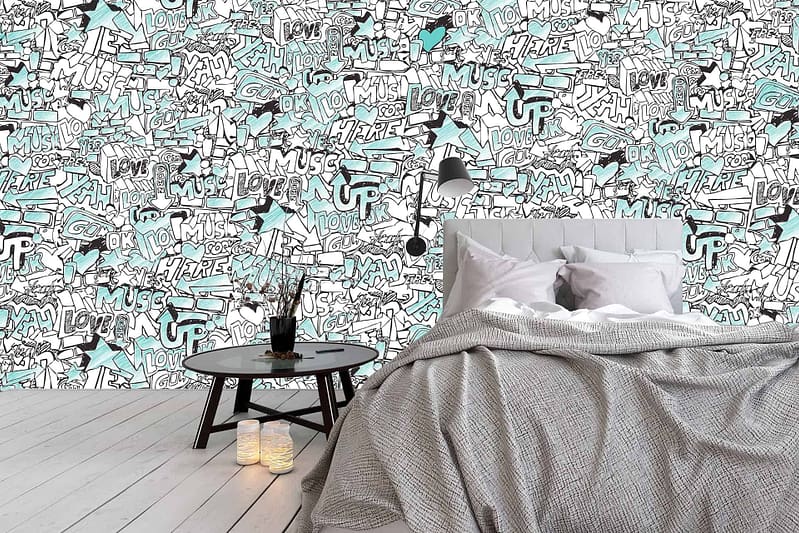 A bedroom wallpaper featuring a vibrant graffiti-style mural includes words like "Love," "Music," and "Fun" in black, white, and teal. The mural is adorned with playful doodles in the same color scheme. This dynamic design adds an energetic and creative vibe to the room.