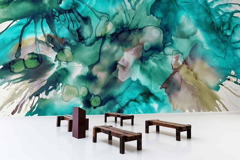 A modern interior showcases a large, abstract watercolor mural in shades of green and teal. The mural features fluid, organic patterns and vibrant swirls, emphasizing its artistic and expressive nature. Keywords: abstract watercolor mural, shades of green and teal, vibrant swirls.