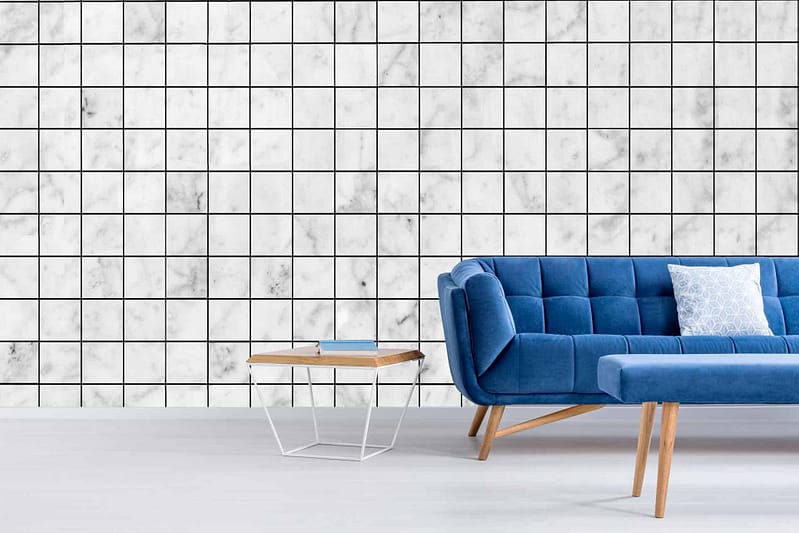 White marble squares tiled on the wall with thin, black grout lines, resembling graph paper.