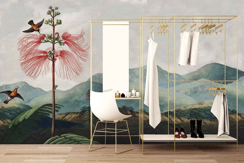 The wallpaper features a mural of vibrant **hummingbirds** and a large **pink flower**, set against lush **green hills** evoking imagery from **Gulliver's Travels**. The scene blends nature's vivid colors, emphasizing the serene beauty of the outdoors.