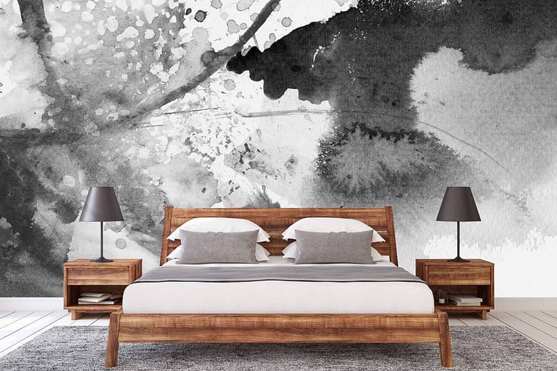 The wallpaper behind the bed features a large black and white abstract mural by acclaimed artist Jade. The mural showcases intricate patterns, dynamic shapes, and flowing lines, creating a striking visual contrast with its monochromatic palette. Elements include bold curves, intersecting lines, and textured shading in shades of black and white.