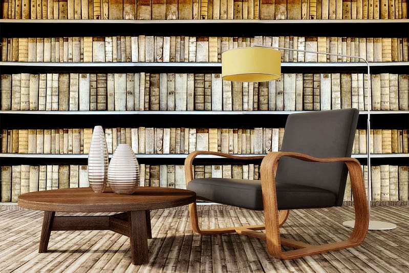 The wallpaper in this cozy reading nook features a delicate pattern of light blue floral motifs on a soft cream background. The design includes intricate vines and small blossoms, creating an elegant and serene atmosphere. Subtle hints of pale green leaves add depth to the overall look.