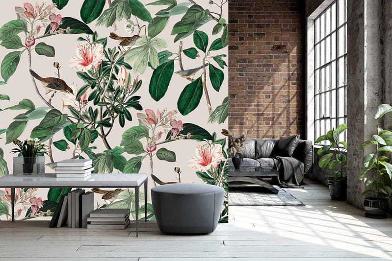 The wallpaper in the modern living space features botanical elements with intricate designs of birds and flowers. It highlights lush green leaves, vibrant blooms in shades of pink, blue, and yellow, alongside elegantly detailed birds perched amidst the flora. This vivid mural brings a lively touch of nature indoors through its rich colors and dynamic patterns.