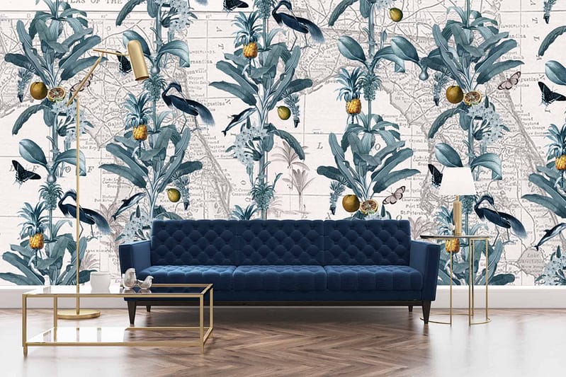 The wallpaper features an intricate design of blue foliage, birds, and pineapples against a vintage map background. The blue shades evoke the relaxed elegance of Miami Beach. Keywords: blue foliage, birds, pineapples, vintage map, Miami Beach elegance.