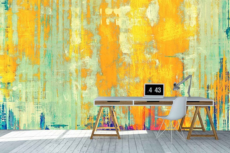 The wallpaper features a vibrant, abstract mural with shades of yellow, orange, and turquoise. It has a distressed texture that suggests it was painted over generations. The interplay of these colors creates a dynamic and energetic backdrop filled with layers and depth.