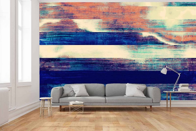 The wallpaper behind the sofa, titled "The Legacy," features an abstract mural with horizontal brushstroke patterns in shades of blue, orange, and white.