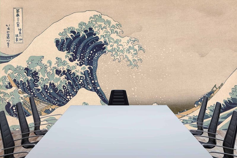 The wallpaper showcases Hokusai's "The Great Wave off Kanagawa" featuring a giant, curling blue wave with white foamy crests, set against a backdrop of muted tones. Small fishing boats are visible amid the turbulent waters. The artwork brings a dynamic mix of deep blues, crisp whites, and subtle grayish tones to the space.