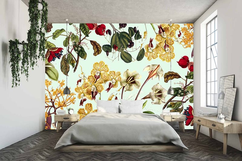 The bold floral accent wall features large, colorful blossoms and lush green leaves. Elements include vibrant reds, pinks, yellows, and blues intertwined with rich green foliage. The wallpaper showcases detailed petals and intricate leaf patterns that bring energy and life to the room.