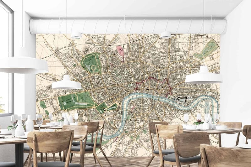 The wallpaper in the restaurant interior features a large vintage map mural of a city in the United Kingdom. The design showcases detailed street grids and a prominent winding river. The colors include muted tones like sepia, beige, and soft blues, with intricate black line work outlining the streets and landmarks.