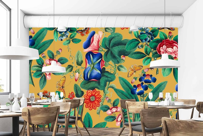 A vibrant, floral mural with large green leaves, colorful flowers, and abstract shapes against a mustard-yellow background. Reminiscent of travel to Valencia, Spain.