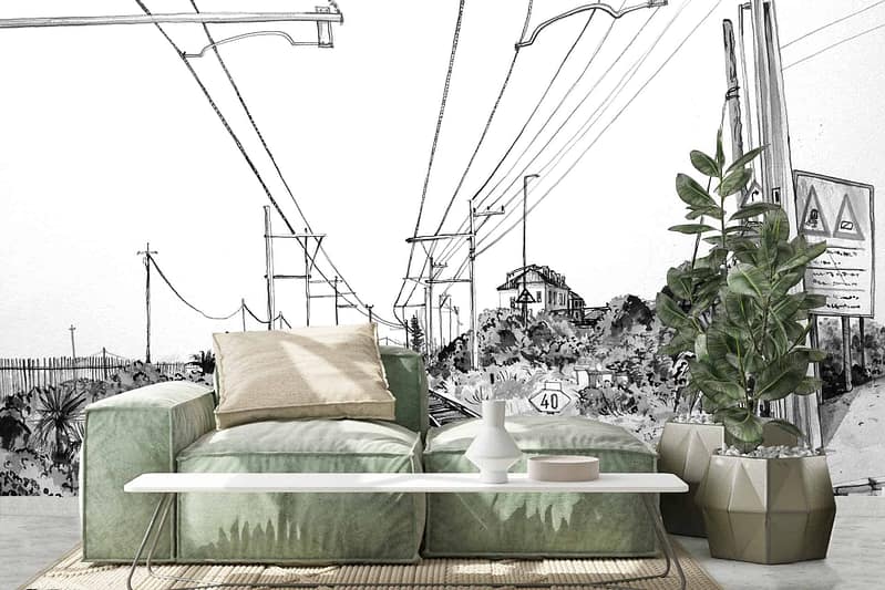 A black-and-white mural depicting power lines, road signs, and a rail crossing in Kalk Bay.