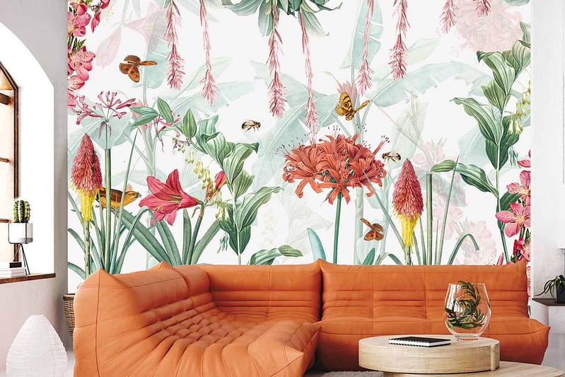 The wallpaper features vibrant flowers, leaves, and flying insects in a variety of colors. Bright pinks, yellows, greens, and blues dominate the mural, creating a lively and cheerful background.