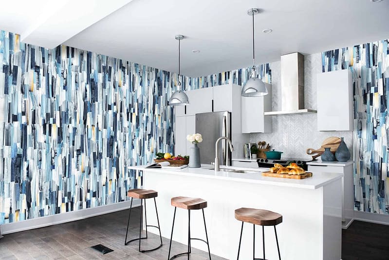 The wallpaper features an abstract pattern with shades of blue, including navy, sky blue, and teal. It incorporates geometric shapes and fluid lines for a dynamic look. Touches of white and silver add contrast and depth to the design.