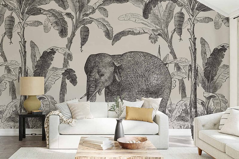 The wallpaper features an intricate mural of an elephant sketched among lush banana trees. Graceful swallows fly across the scene, adding a whimsical touch. The colors include shades of gray for the elephant, rich greens for the banana leaves, and soft blues for the swallows.