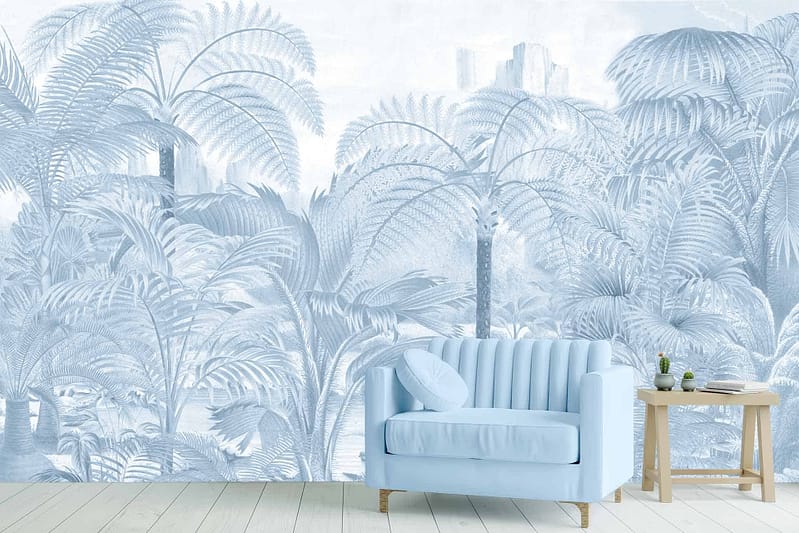 The wallpaper features lush, leafy tropical designs with palm trees and dense foliage. The colors include shades of green for the leaves and fronds, with hints of pastel blues intermingling among the greenery. This creates a vibrant but serene backdrop, capturing a tropical paradise feel with soft pastel accents that dominate the overall aesthetic.