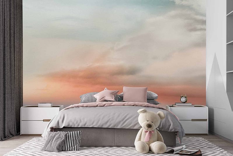 The wallpaper behind the bed showcases a mural of a cloudy sky. It features soft shades of pink and blue, creating a dreamy atmosphere. Elements include fluffy clouds with subtle gradients blending pink and blue hues seamlessly.