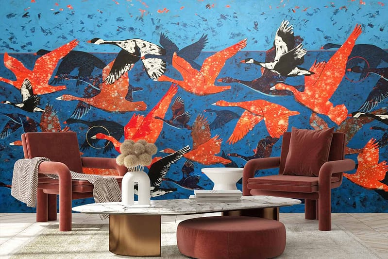 A vibrant mural of red, orange, and black birds flying against a bright blue background.