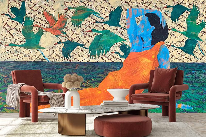 The wallpaper features a blue-skinned person in an orange dress, surrounded by netting and green birds. The backdrop includes modern elements like two red armchairs, a white and gold pedestal coffee table, and a decorative vase with pampas grass. Key colors are blue, orange, green, red, white, gold.