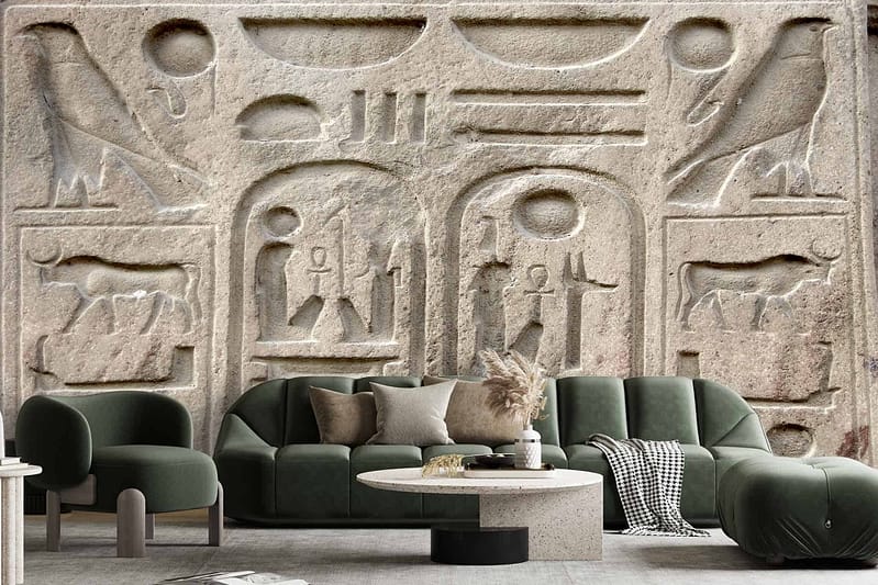 Detailed ancient Egyptian hieroglyphic engravings wallpaper featuring various symbols, birds, and human figures. Elements include intricate carvings and historic iconography with colors such as gold, beige, sandstone, and emerald green.