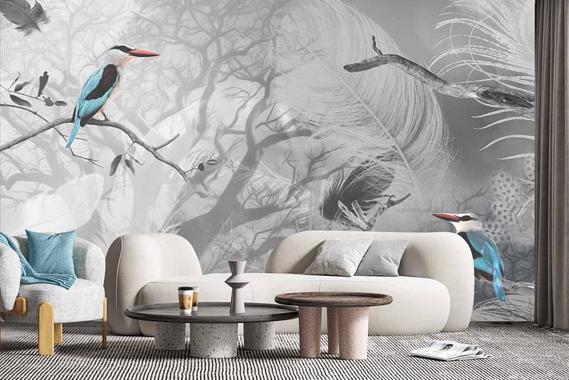 A modern living room features a nature-themed wallpaper adorned with birds and feathers. Predominantly in grayscale, it also incorporates varying shades of blue to accentuate the intricate details. The design brings a serene yet sophisticated touch to the space, blending natural motifs with contemporary styling.