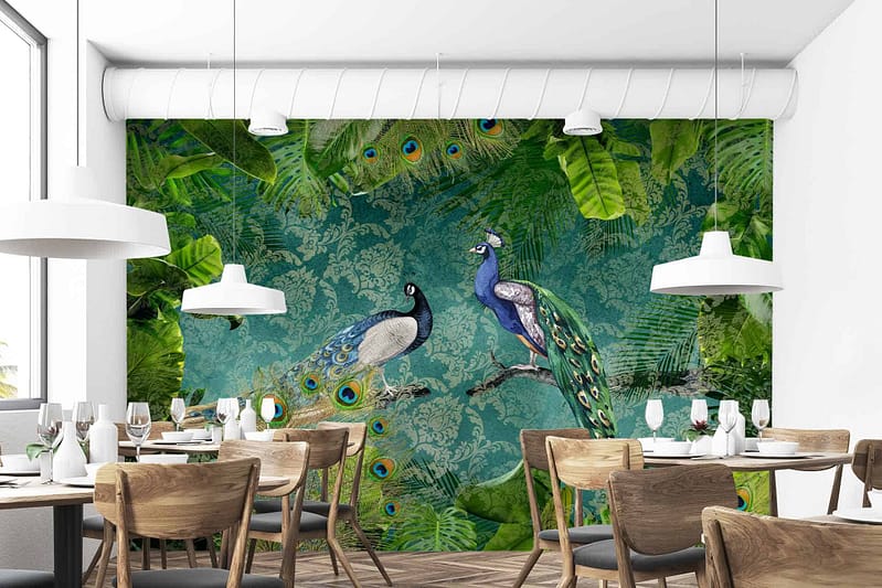 The wallpaper features a vibrant mural with two peacocks perched on branches. The background showcases an array of green leaves and lush foliage. The primary colors are blue and green, complemented by accents of white and brown from the branches. Rich, intricate details emphasize the feathers of the peacocks and the natural greenery surrounding them.
