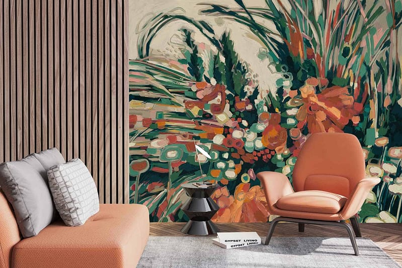 A modern living room features a bold, abstract floral mural in vibrant colors. The wallpaper showcases dynamic shapes with hues of turquoise, magenta, and lime green intertwining with splashes of gold and coral accents. The design brings energy to the space with its lively patterns and vivid palette.