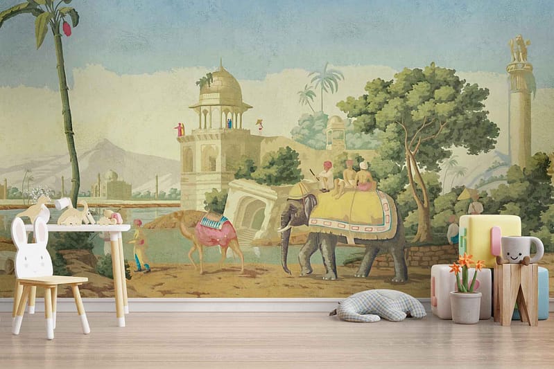 The wallpaper features a colorful mural of an exotic scene with a majestic elephant and a graceful camel, each ridden by figures in traditional attire. Ancient buildings with intricate details stand proudly amongst lush greenery, including palm trees and vibrant foliage. The mural showcases rich colors such as deep greens, earthy browns, golden yellows, and vivid blues, creating an immersive and lively atmosphere perfect for a child's imagination.