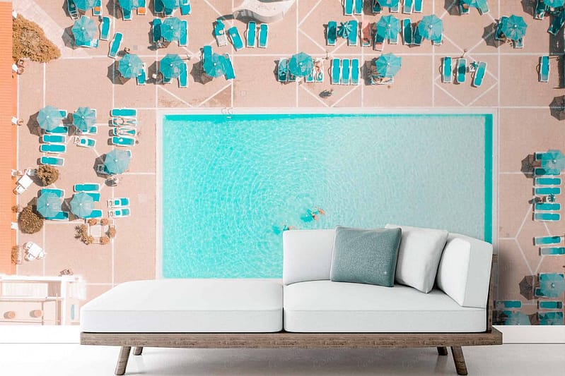 Wallpaper features an aerial view of a swimming pool with turquoise umbrellas, sun loungers, and surrounding area. Predominant colors include turquoise, blue, and white.