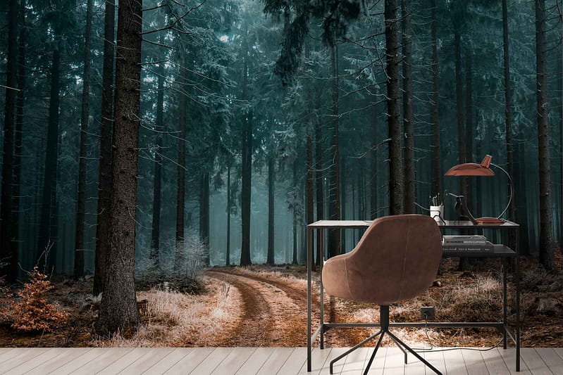 The wallpaper features an ethereal, misty forest path lined with tall trees and scattered leaves. The dominant colors are shades of green and brown from the foliage and tree trunks, with hints of soft gray mist adding a dreamy effect.