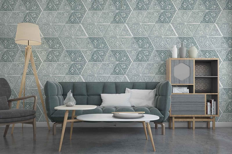 The wallpaper features a bold, geometric pattern with interlocking shapes. Dominant colors include shades of teal, mustard yellow, and white. Some areas have subtle silver accents that add a touch of metallic sheen. The geometric design creates a dynamic, contemporary feel perfect for modern living spaces.