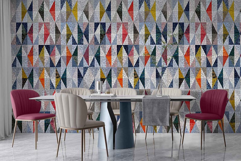 The wallpaper features a geometric mosaic pattern composed of colorful triangles in various shades. The colors include red, blue, yellow, and white. The design creates a vibrant and dynamic aesthetic on the wall.