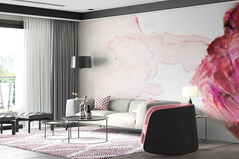 The wallpaper in the modern living room showcases large abstract patterns with soft pink hues and subtle gray accents. This textured design complements the room's minimalist theme while incorporating color elements that match the pink-accented chair and light gray sofa.