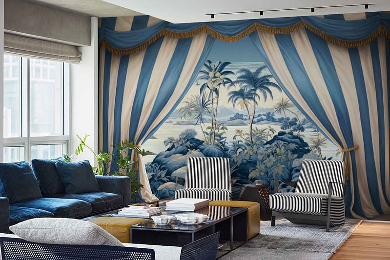 The wallpaper features a large, bold mural of a tropical landscape with palm trees and a scenic view, styled to appear framed by theatrical blue and white curtains with gold trim. The design includes lush green palm leaves, deep blue waters, rich earth tones for the landscape, and vivid hues for the sky.