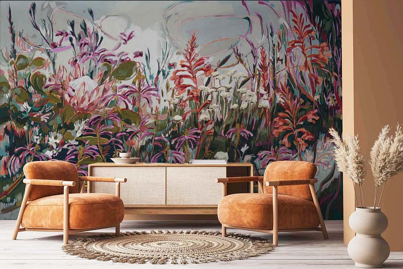 A large, vibrant floral mural featuring Abstract Pincushion Proteas. The wallpaper showcases elements of bold pincushion protea flowers in rich hues of orange, deep red, and golden yellow, with intricate detailing and abstract forms. The background includes subtle shades of green and soft blues mingling seamlessly to enhance the floral design.