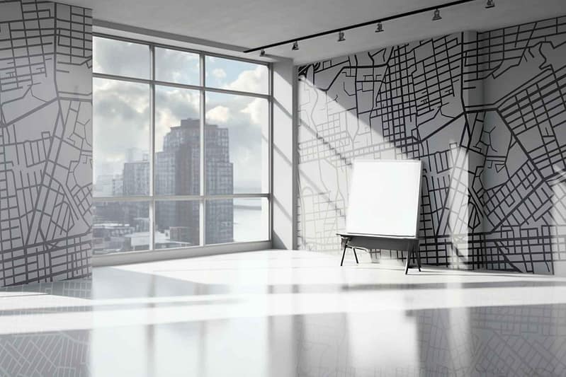 Abstract map design wallpaper featuring black and white tones. Resembling "Where The Streets Have No Name." Detailed with intricate street patterns in monochrome, providing a modern, artistic touch. Urban elements depicted with sharp contrasts and geometric forms. Perfect for highlighting against natural light from floor-to-ceiling windows in a spacious office setting.