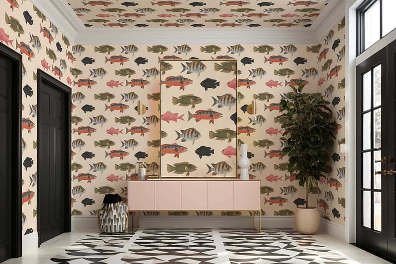 The wallpaper features a vibrant fish theme with various colorful fish depicted on both the walls and ceiling. You'll find hues of aqua, coral, gold, and turquoise throughout the design. The fish are intricately detailed, offering a lively underwater ambiance. The background often shifts between soft blue gradients and sandy beige tones to mimic an aquatic environment.