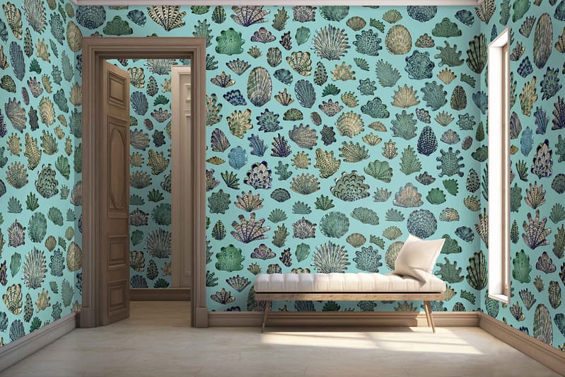 The wallpaper is adorned with a colorful coral reef pattern, showcasing various shades of blue, green, and beige. It features detailed depictions of underwater elements like corals, seaweed, and marine life. The hues range from deep cerulean to pale aquamarine and forest green to soft moss. Beige accents highlight sandy seabed textures scattered throughout the design.