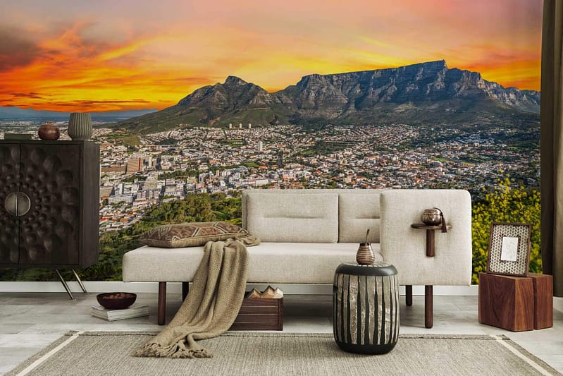 Cityscape wallpaper with mountains, vibrant sunset sky, dramatic backdrop for dreams of flying. Colors: shades of orange, pink, purple, blue, and silhouettes of buildings and mountains.