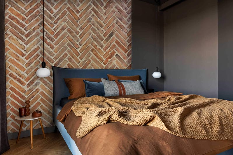 The wallpaper features a decorative herringbone brick pattern that is accentuated by shadow lines. The color palette includes shades of dark blue, brown, tan, and gray.
