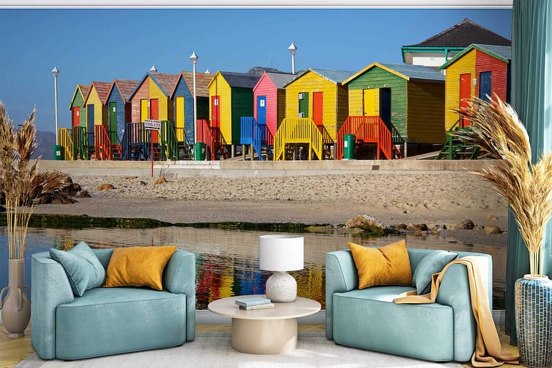 Colorful beach huts wallpaper features vibrant hues, including teal, yellow, red, and blue. The background showcases a dynamic coastal scene with lively contrasts and playful beachside elements.