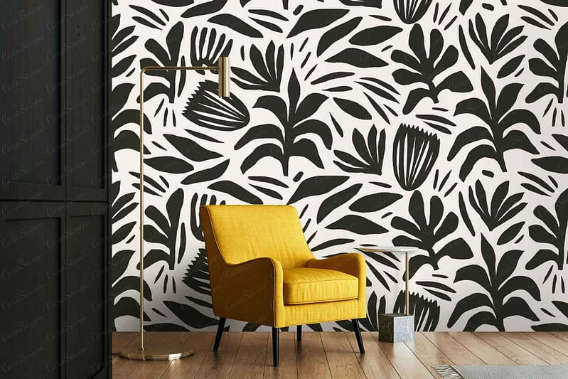 A modern living room showcases bold black and white botanical-patterned wallpaper featuring intricate leaves and floral designs in contrasting shades of deep black and crisp white.
