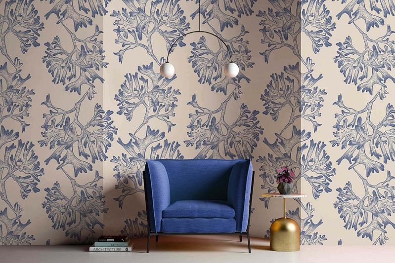Beige wallpaper adorned with intricate blue floral patterns. Elements: floral motifs, swirls, and vines in varying shades of blue on a beige background.