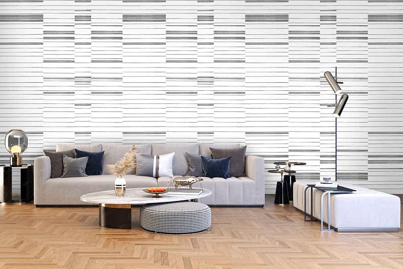 The wallpaper is adorned with a chic geometric pattern that integrates various shades of blue and gray, mirroring the room's pillows. The design features intricate lines and shapes, creating an engaging visual texture. This backdrop elegantly complements the room’s modern aesthetic with its harmonious blend of colors and patterns.