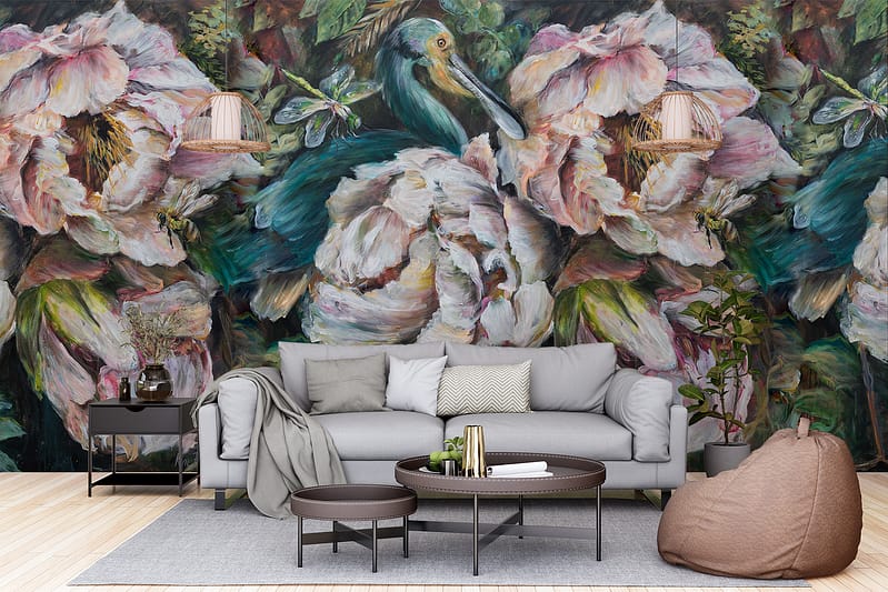The wallpaper features a large, vibrant mural of a bird painted in vivid hues like teal, orange, and yellow. Surrounding the bird are abstract floral designs incorporating deep green foliage, pastel pink flowers, and splashes of bright red petals. Hints of metallic gold accents add a dynamic dimension to the overall design. The bold color contrasts and intricate detailing make this wallpaper a focal point in any modern living room setting.