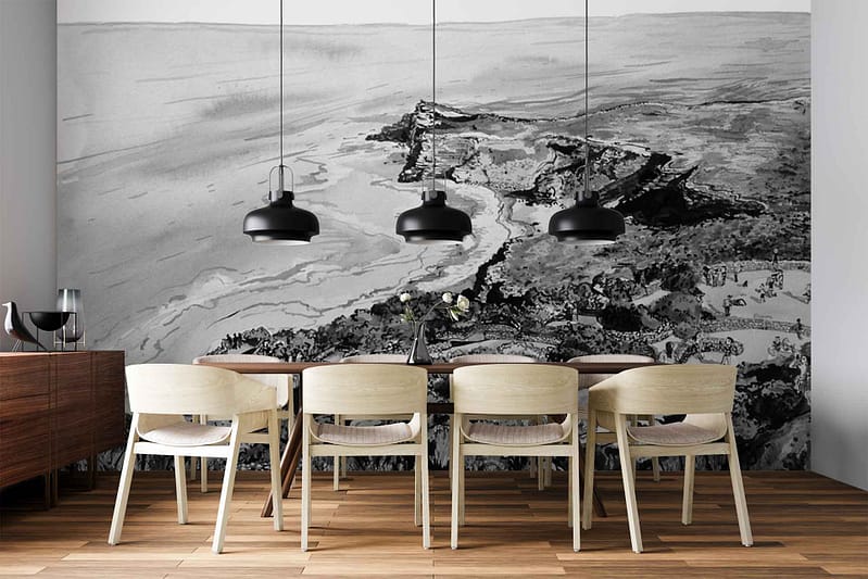Large black-and-white mural wallpaper depicting a coastal landscape: features rolling hills, dramatic cliffs, ocean waves, distant boats, and windswept trees in grayscale tones.