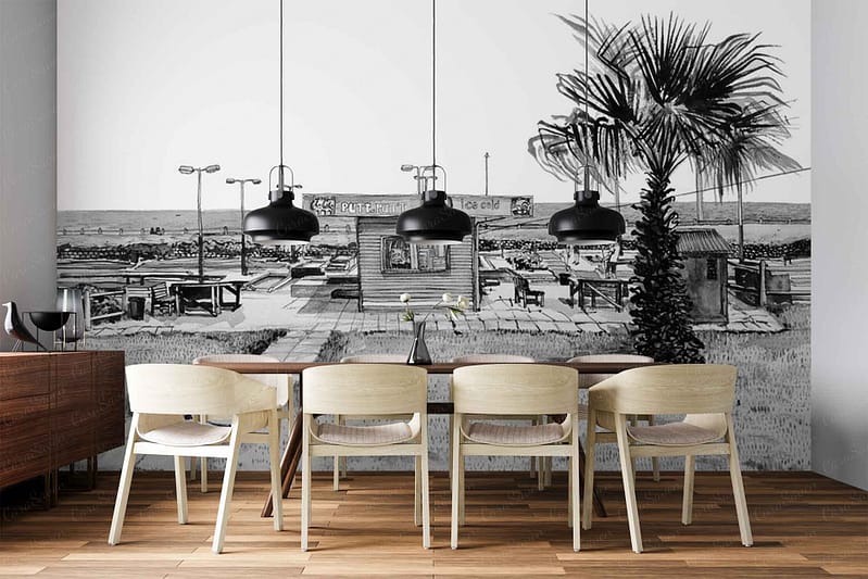 Black-and-white wall mural featuring a beachside café scene: palm trees, lounge chairs, café tables and chairs, with the ocean and sky in the background. Monochrome palette—shades of black, white, and gray—creates a serene coastal atmosphere.