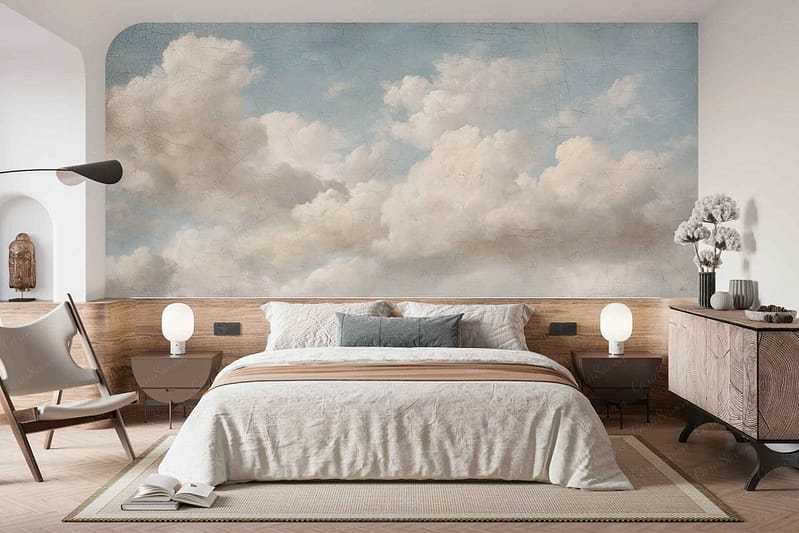 The wallpaper features a modern cloud mural in soft, neutral tones—primarily beige, white, and warm greys. The design showcases gentle, painterly clouds with subtle gradients and blurred edges for a calming, dreamy effect. Hints of cream and taupe add depth without overpowering the minimalist aesthetic.